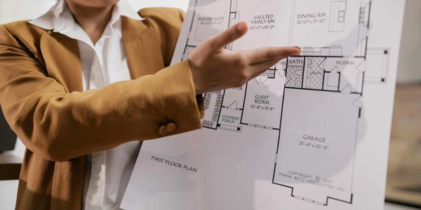 Person presenting a detailed first floor architectural plan.