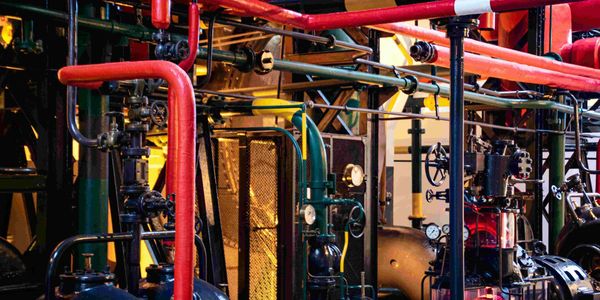 Complex industrial machinery with colorful pipes and gauges.