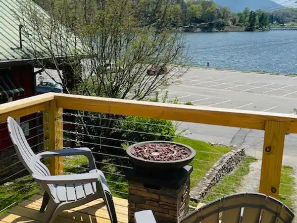 Private deck at Lake Life Upper Apartment with Adirondack chairs, fire pit, and Lake Junaluska views