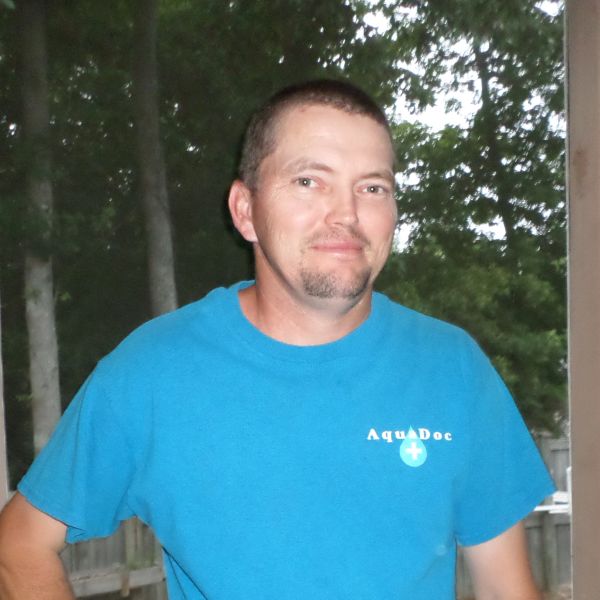 Man in a blue AquaDoc t-shirt outdoors.