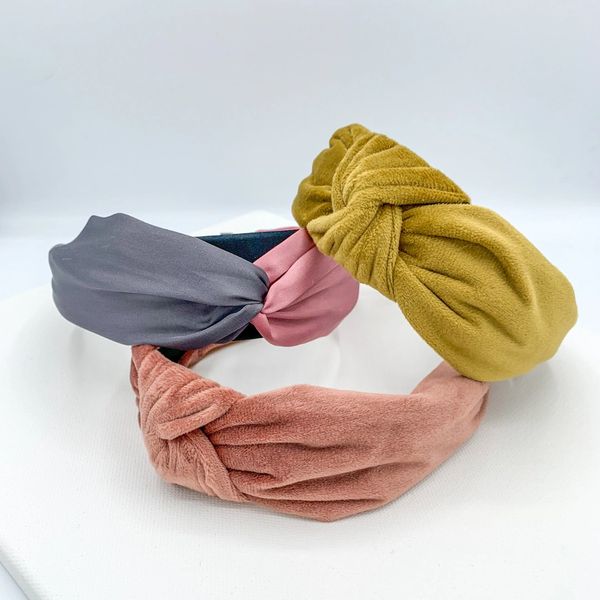 Three headbands. one is pink and crushed velvet with a knotted middle. One is mustard with knotted m