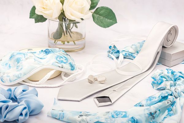 Silver tie with floral blue hair accessories. A minimal wedding accessories table.
