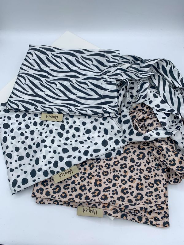 Three fabric tote bags in leopard print, dalmatian print and zebra print.