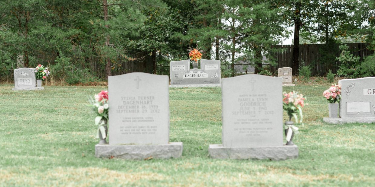 Gravestones in a peaceful cemetery surrounded by trees.