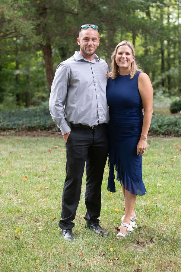 Couple posing outdoors, smiling.