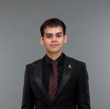 Man in a black suit with a burgundy striped tie.