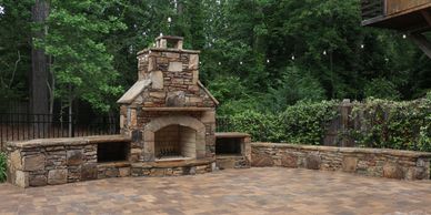 Outdoor stone fireplace in a backyard patio.