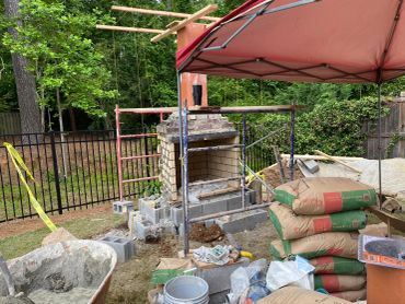 Backyard stone fireplace under construction.