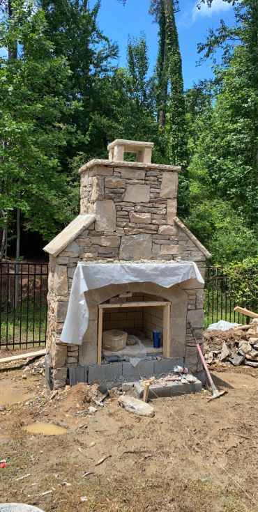 Outdoor stone fireplace under construction.