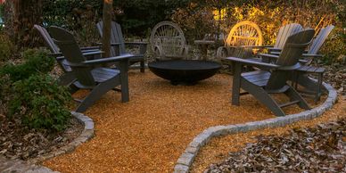 Outdoor seating area with chairs around a fire pit.