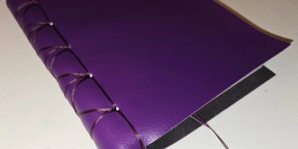 Purple book with intricate stitching on the spine.