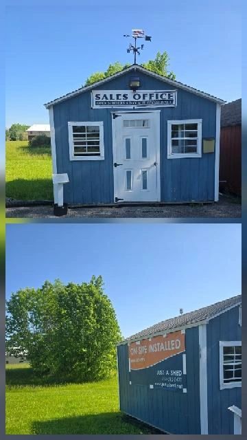 Small blue sales office shed with a weather vane on top in a grassy area.