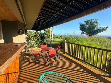 Terrasse ensoleillée avec mobilier de jardin coloré.