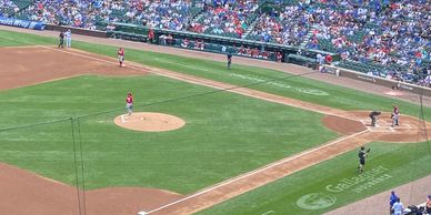 Baseball game with pitcher on mound and batter at plate in a crowded stadium.