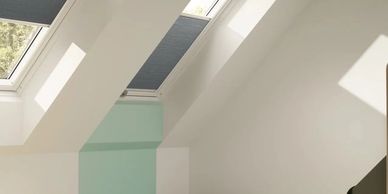 Bright attic room with skylights and a mint green wall section.