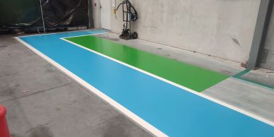 A clean, colorful floor section with blue and green panels in an industrial space.