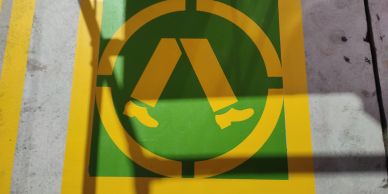 Yellow and green pedestrian crossing sign on the ground.