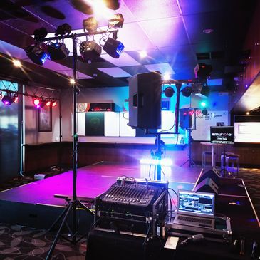 Empty stage with colorful lighting and sound equipment ready for a performance.