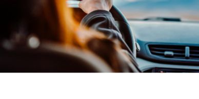 View from the backseat of a person driving a car.