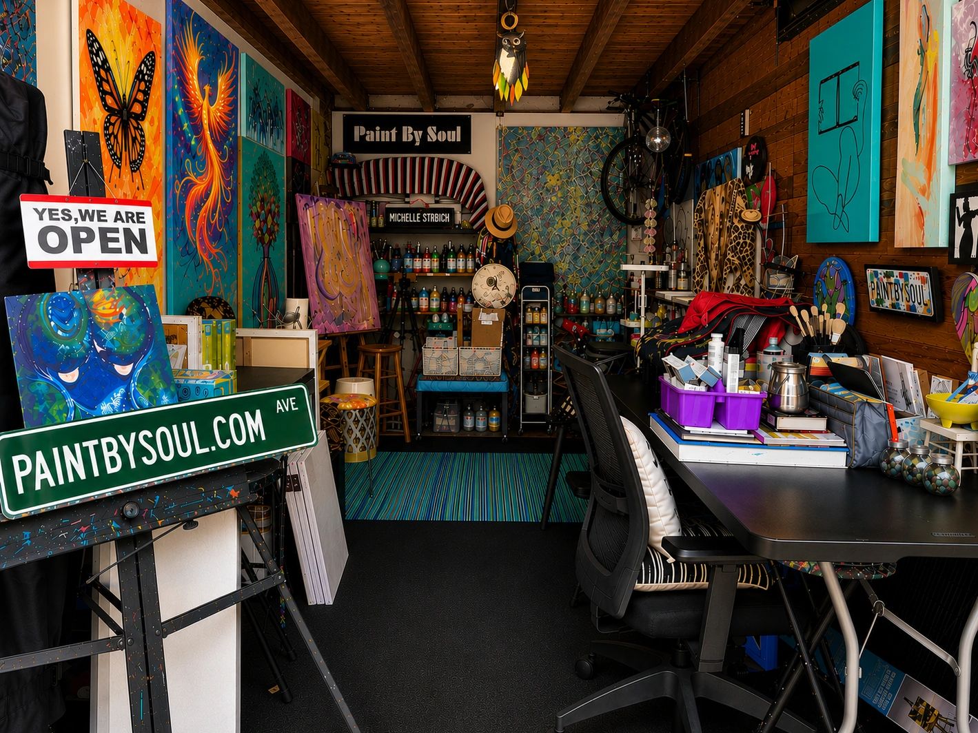 Colorful and vibrant art studio with paintings and supplies.