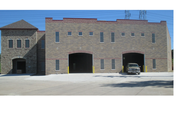 multi textured 2 story concrete block building with red edging.  multiple sized windows, doors and g