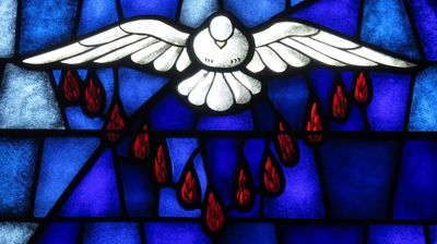 Stained glass dove with red drops on a blue background.