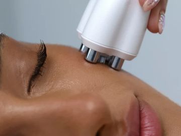 Close-up of a facial treatment with a handheld device on the cheek.