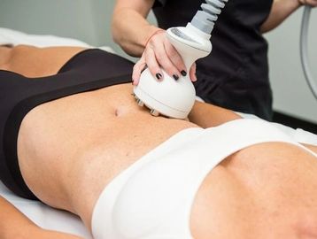 Woman undergoing a body contouring treatment on her abdomen.