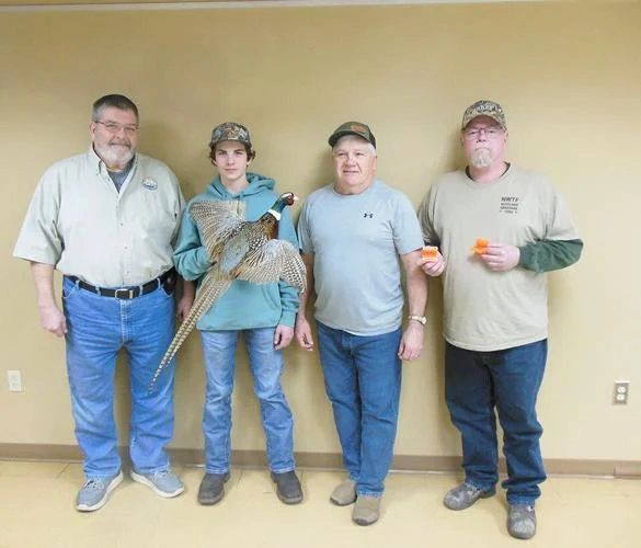 Hudson Miller, center, seen with his prized pheasant and, from left, Greg Gerou and Mark Althoff of the Red River Area Sportsmen's Club and Brad Glarum of the National Wild Turkey Federation.