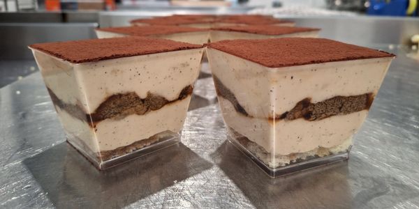 Tiramisu desserts with cocoa powder on top.
