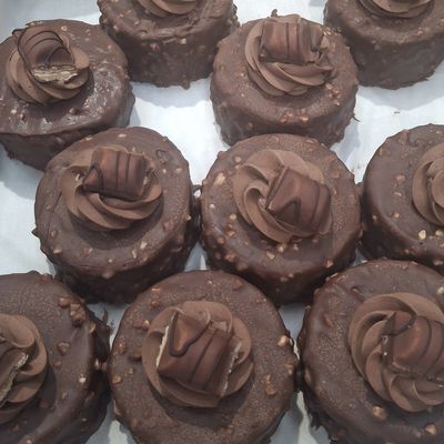 Round chocolate cakes topped with chocolate cream and a piece of chocolate candy.