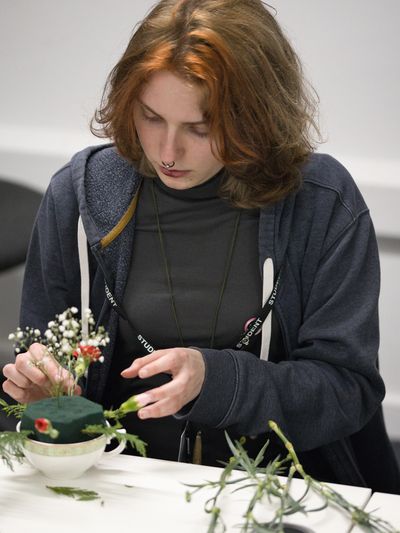 Person arranging flowers in a foam base.