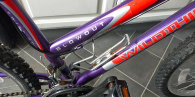 Close-up of a purple and red mountain bike frame with the brand name "WILDN-HILL" and model "BLOWOUT".