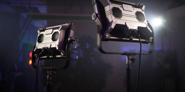 Two studio lights shining in a dark room.