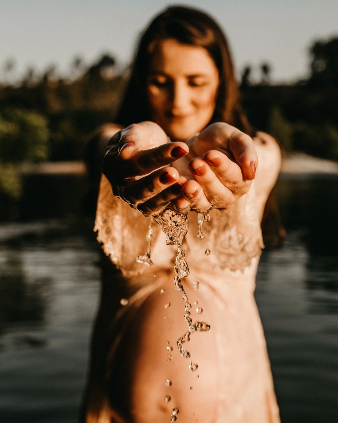 Pregnant woman, holding water in her hands.