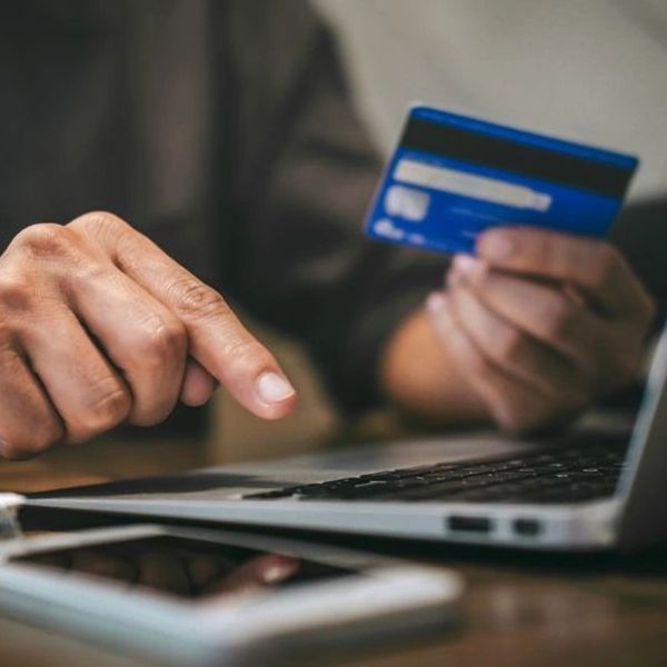 Person using laptop and credit card for online payment.