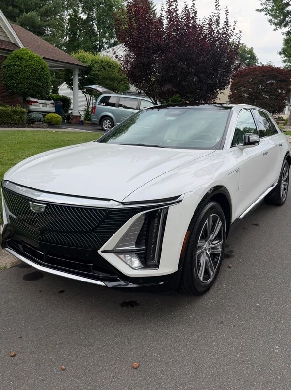 White Cadillac SUV parked on a residential street.