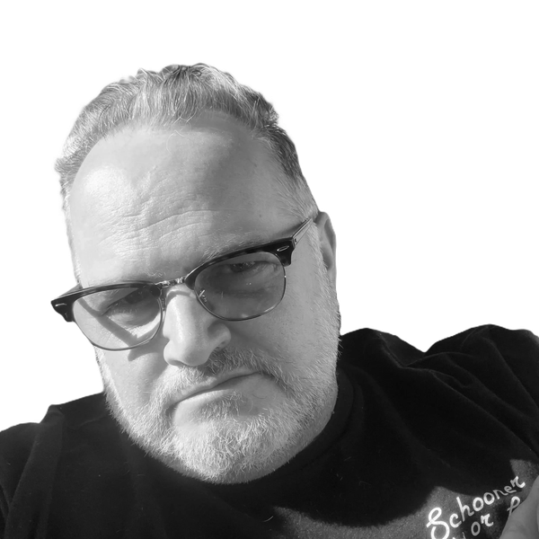 Black and white close-up portrait of a man with glasses.