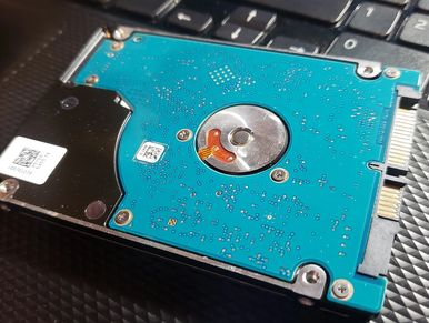 A hard drive sitting on a laptop palmrest