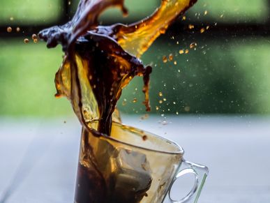 A cup of espresso, mid-spill