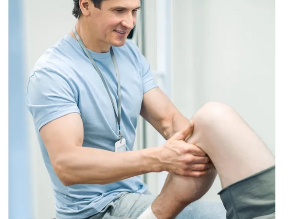 Manual Physical Therapy is being performed on the knee of a patient.