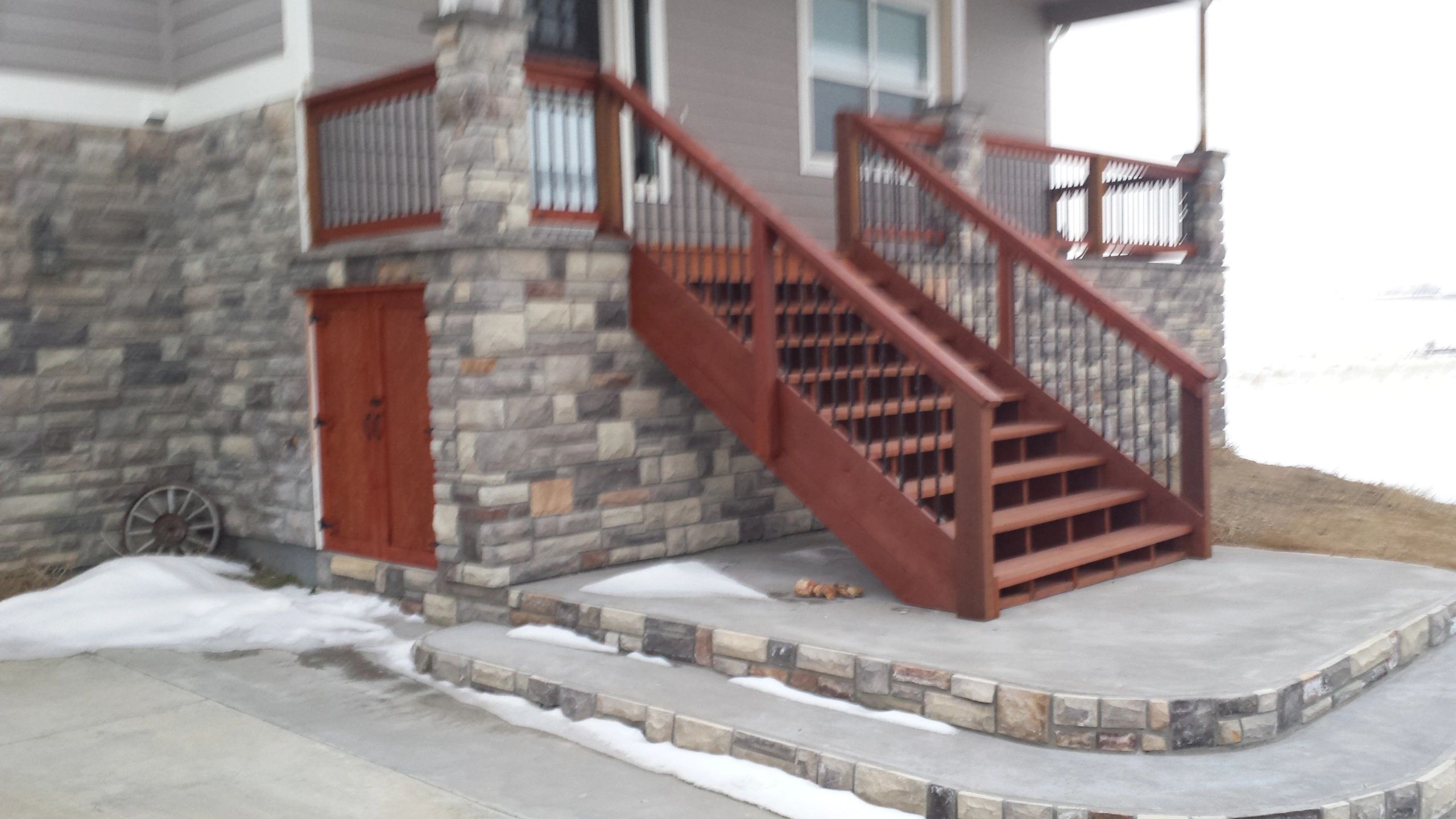 Exterior deck stairs with metal balusters, and storage underneath. 