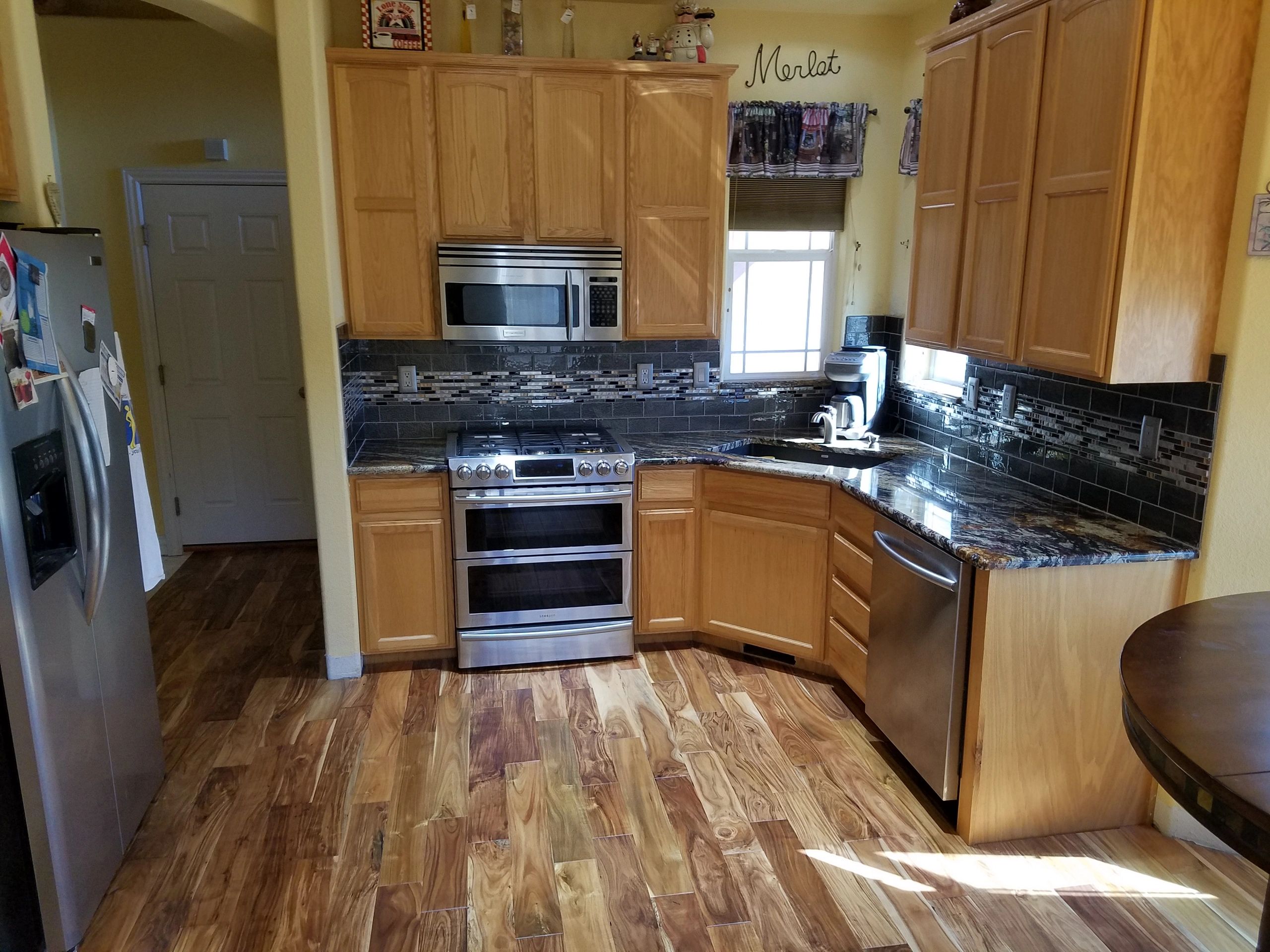 Kitchen remodel with new Acacia hardwood flooring, granite countertops, and glass tile backsplash. 