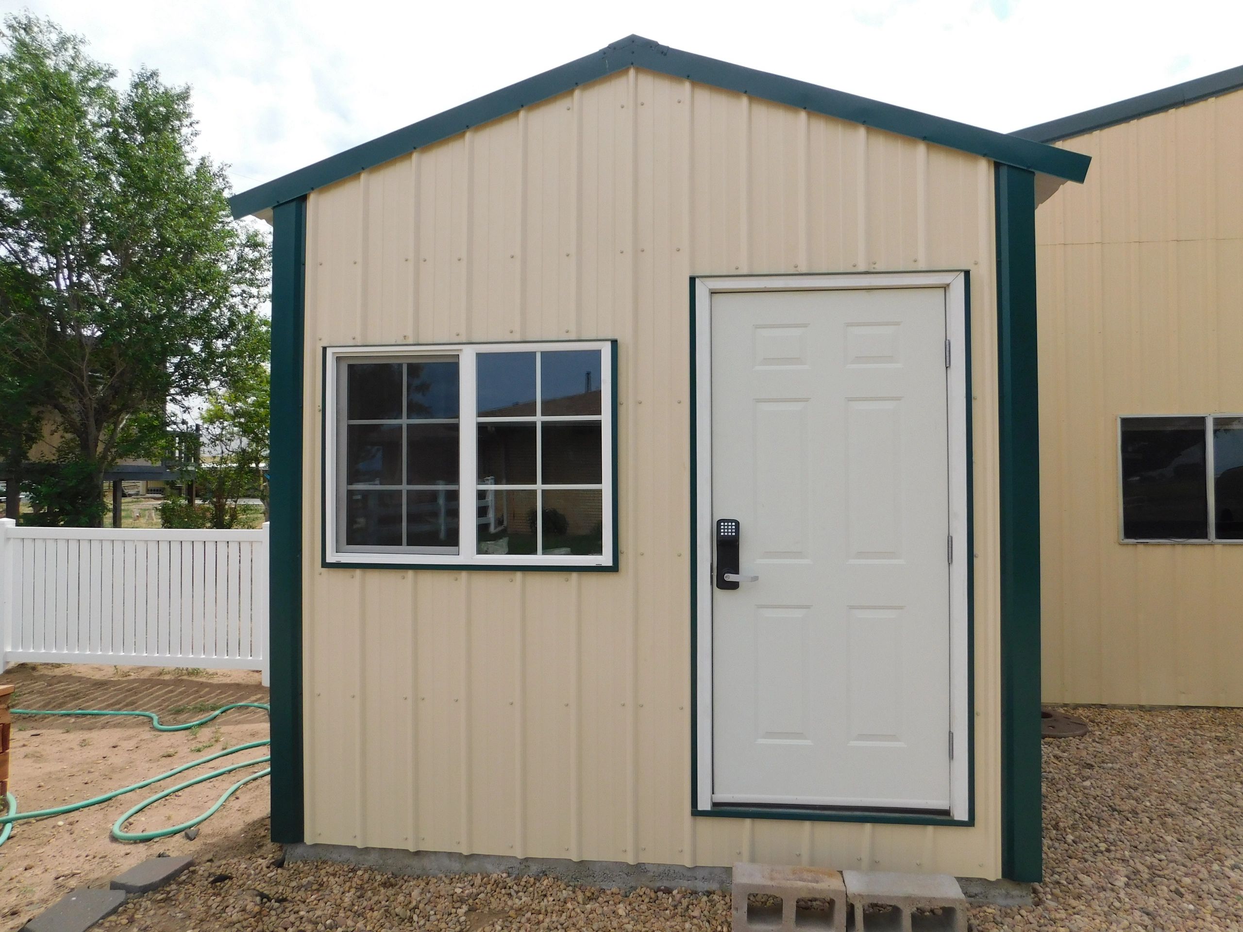 Wood framed shed with metal siding.
Includes a 3' door on the west side and a 4' roll up garage door