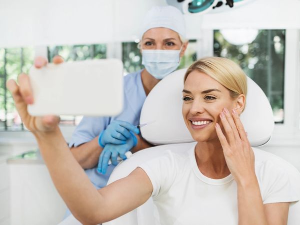 Beautiful and happy blonde woman at medical beauty clinic. 