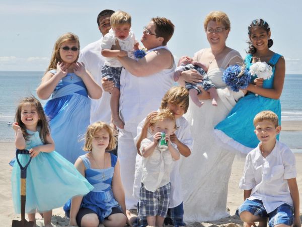A group of people in blue and white outfits posing on a beach.