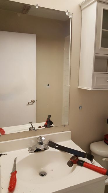 Bathroom sink with tools on it and a mirror above.