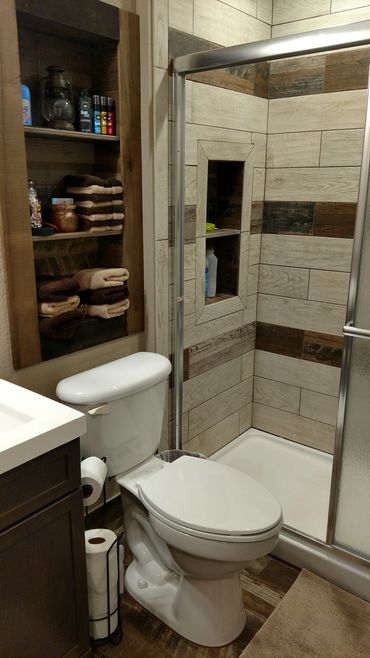 Cozy bathroom with shower, toilet, and towel storage.