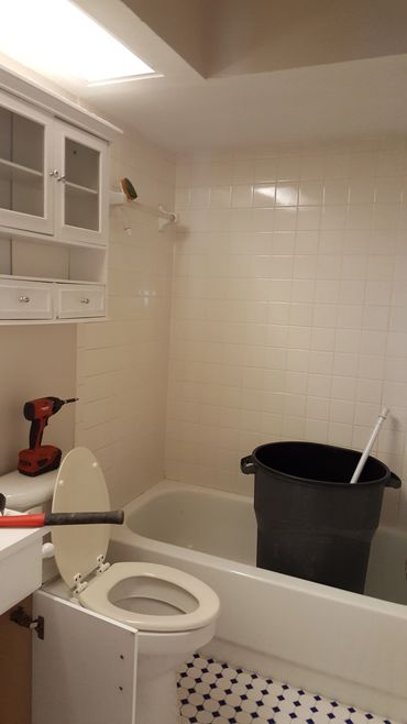 Bathroom under renovation with tools and bucket.