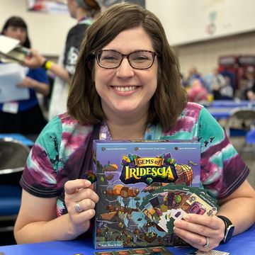 Laura Dunn from @obsessedwithboardgames with the new Gems of Iridescia High Score at Gen Con 2024.